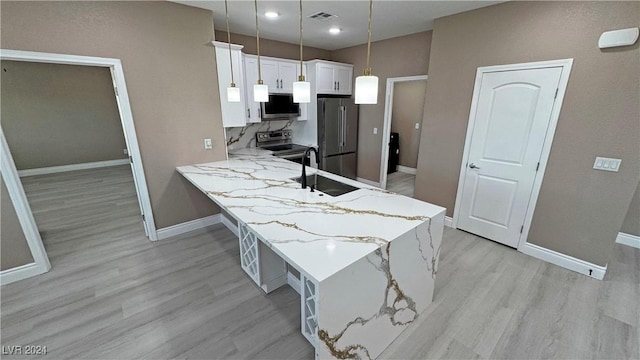 kitchen with kitchen peninsula, light hardwood / wood-style flooring, decorative light fixtures, white cabinetry, and stainless steel appliances