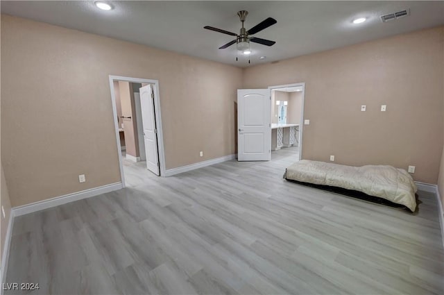 unfurnished bedroom featuring light wood-type flooring, connected bathroom, and ceiling fan