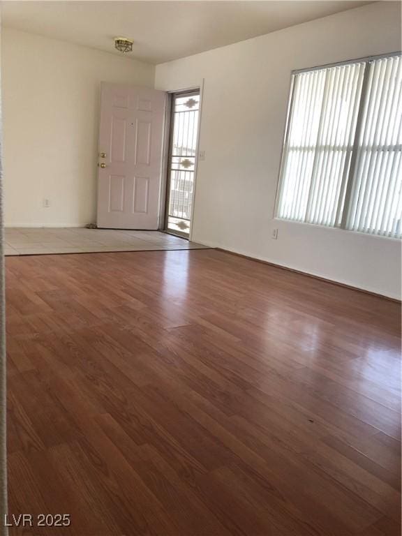 unfurnished room featuring dark hardwood / wood-style flooring and a wealth of natural light