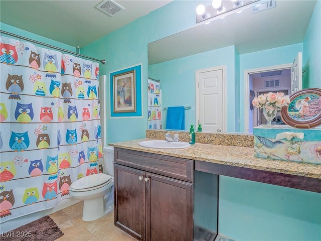 bathroom with tile patterned floors, vanity, toilet, and walk in shower