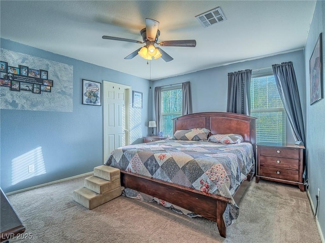 carpeted bedroom with multiple windows and ceiling fan