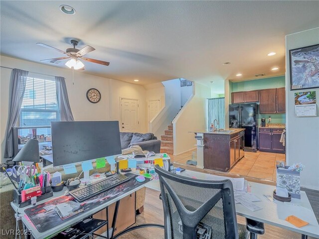 office area with ceiling fan, light hardwood / wood-style flooring, and sink