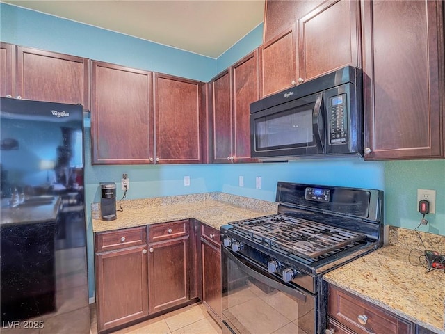 kitchen with light stone counters, light tile patterned floors, and black appliances