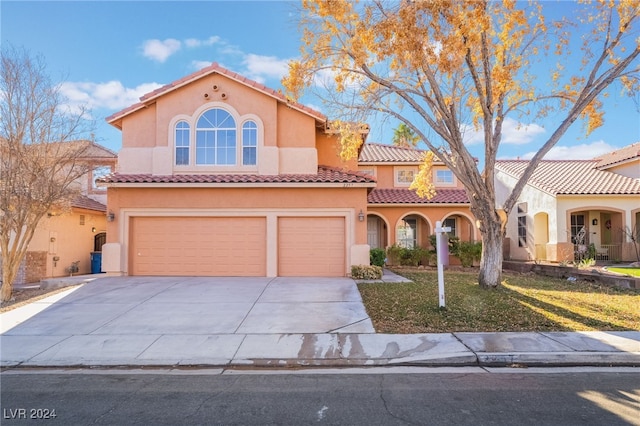 mediterranean / spanish-style home with a front lawn and a garage