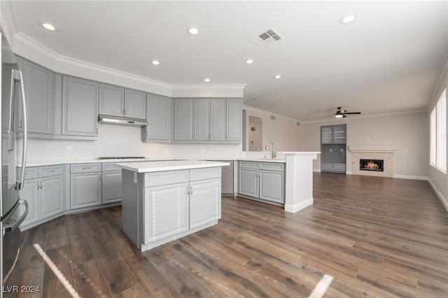 kitchen featuring gray cabinets, stainless steel refrigerator, ceiling fan, ornamental molding, and a kitchen island