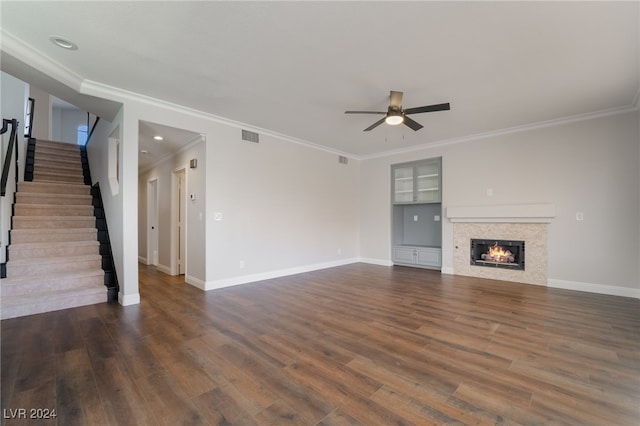 unfurnished living room featuring ceiling fan, built in features, crown molding, and dark hardwood / wood-style floors