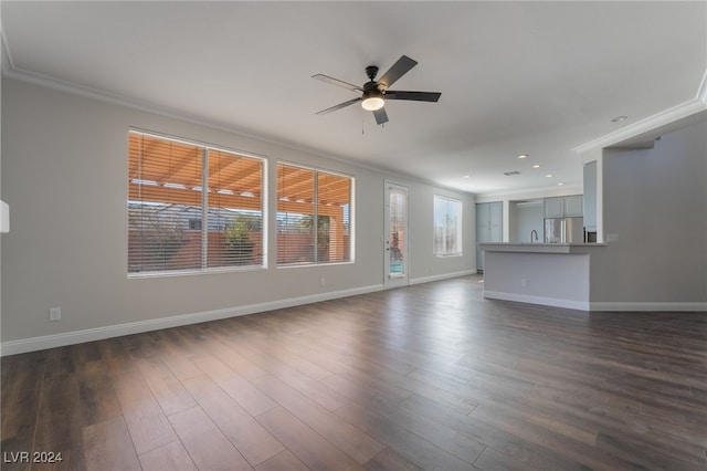 unfurnished living room featuring ornamental molding, ceiling fan, and dark wood-type flooring