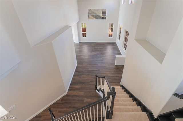 stairs featuring a high ceiling and hardwood / wood-style floors