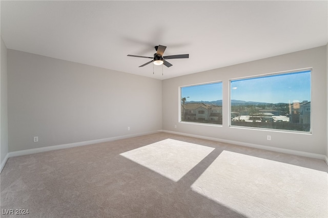 unfurnished room featuring ceiling fan and carpet