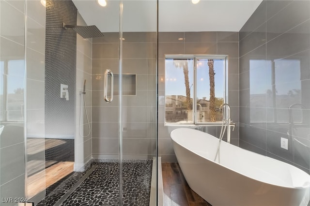 bathroom featuring tile walls and shower with separate bathtub