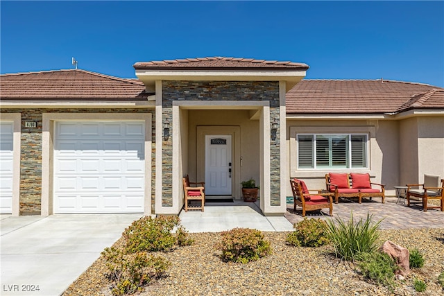 view of front of home with a garage and an outdoor hangout area