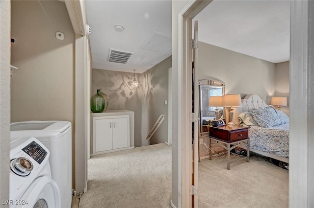 washroom featuring washer and dryer, a notable chandelier, and light carpet