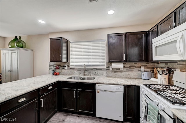 kitchen with white appliances, light hardwood / wood-style flooring, tasteful backsplash, sink, and dark brown cabinetry