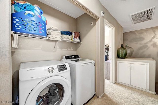 laundry area featuring washer and clothes dryer and light carpet