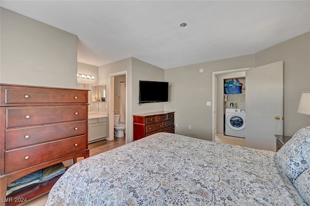 bedroom featuring washer / clothes dryer, light hardwood / wood-style flooring, and ensuite bath