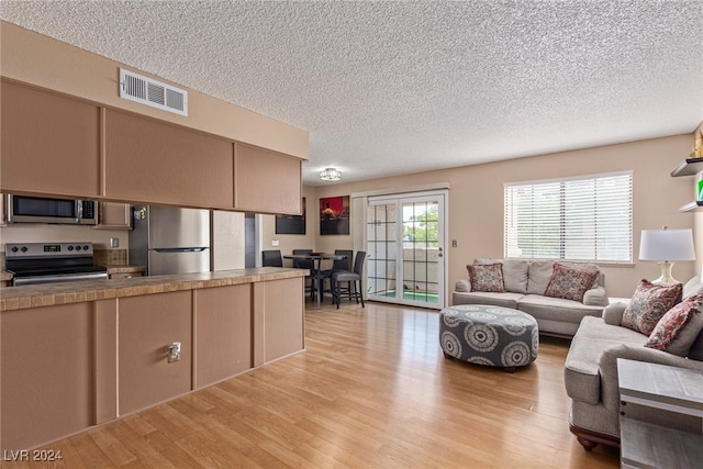 living room featuring a textured ceiling and light hardwood / wood-style floors