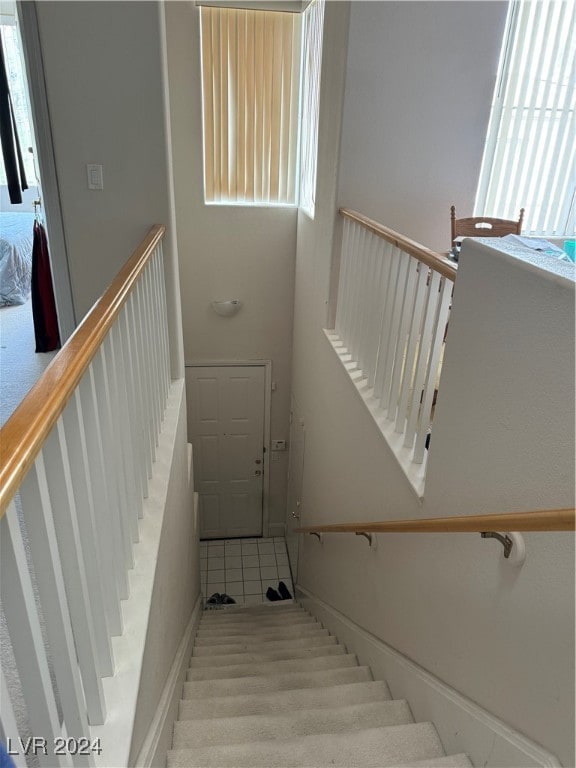 stairway featuring tile patterned flooring