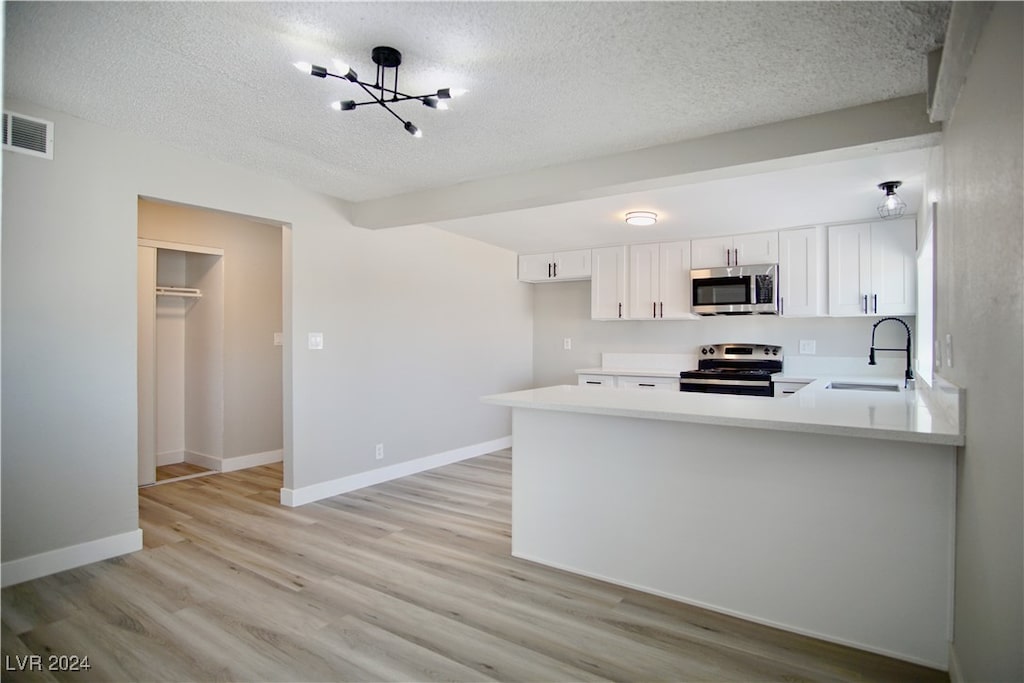 kitchen with white cabinetry, stainless steel appliances, kitchen peninsula, sink, and light hardwood / wood-style floors