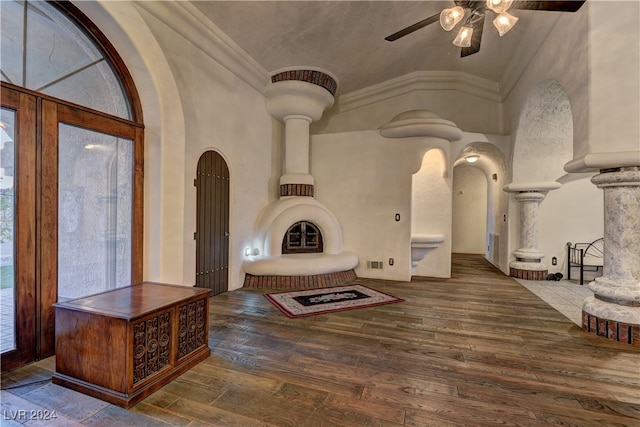 foyer featuring vaulted ceiling, wood-type flooring, ceiling fan, and ornate columns