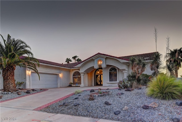 mediterranean / spanish-style home with a garage