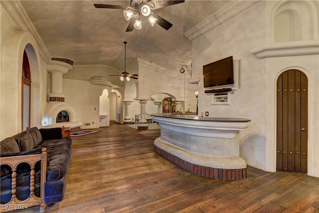 interior space featuring dark wood-type flooring, ceiling fan, high vaulted ceiling, and crown molding