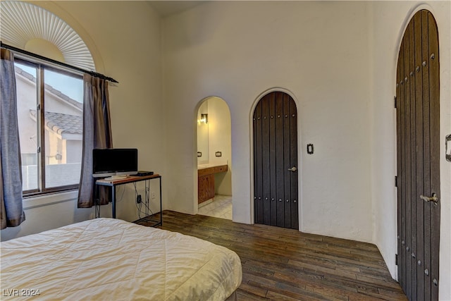 bedroom with hardwood / wood-style floors, ensuite bathroom, and multiple windows