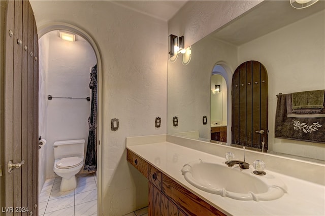 bathroom featuring vanity, toilet, and tile patterned flooring