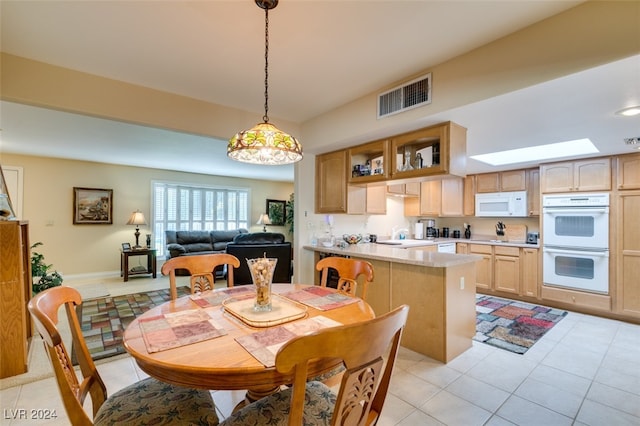 dining room featuring light tile patterned floors and a skylight