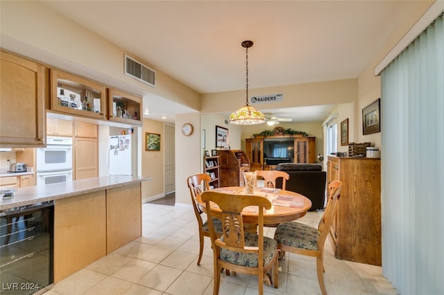 dining room featuring ceiling fan, wine cooler, and light tile patterned flooring