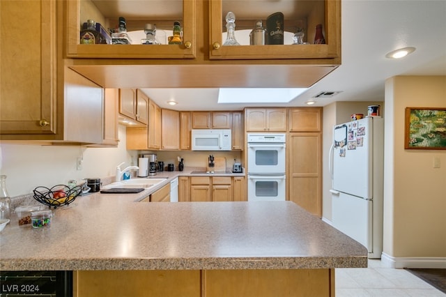 kitchen featuring kitchen peninsula, sink, light tile patterned floors, and white appliances