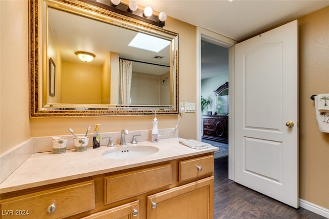 bathroom featuring a skylight, wood-type flooring, and vanity