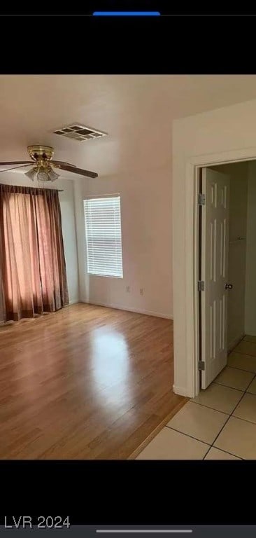 spare room with ceiling fan and light wood-type flooring