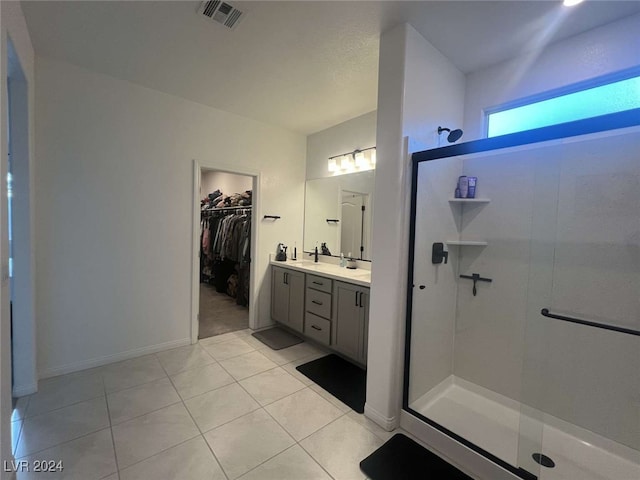 bathroom with tile patterned flooring, vanity, and a shower with door