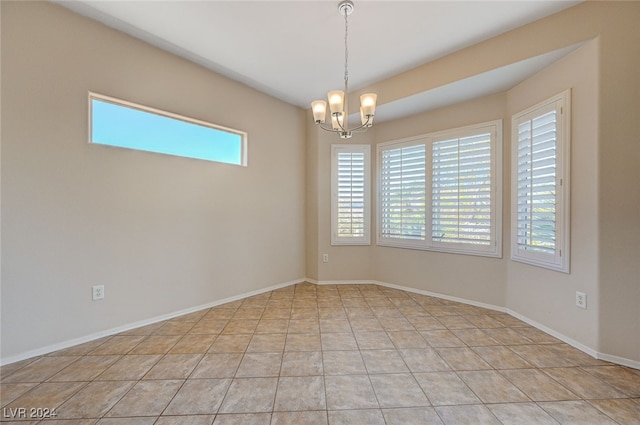 tiled empty room featuring a chandelier and a healthy amount of sunlight