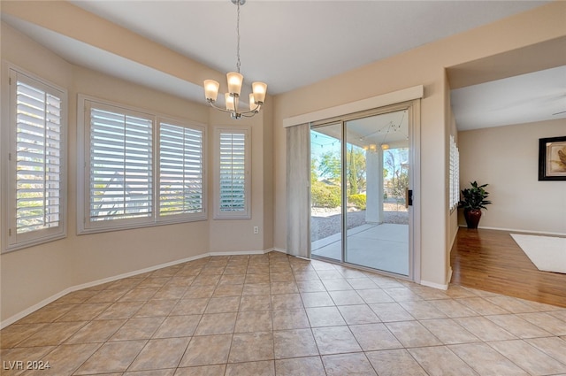 unfurnished dining area featuring light tile patterned flooring and a chandelier