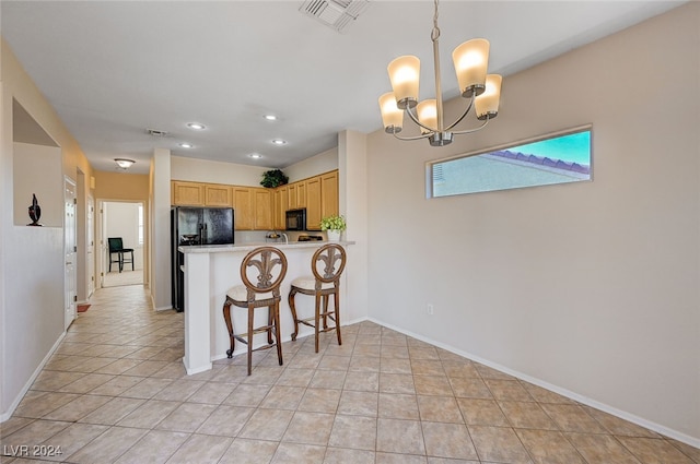 kitchen featuring light brown cabinets, an inviting chandelier, decorative light fixtures, light tile patterned floors, and black appliances