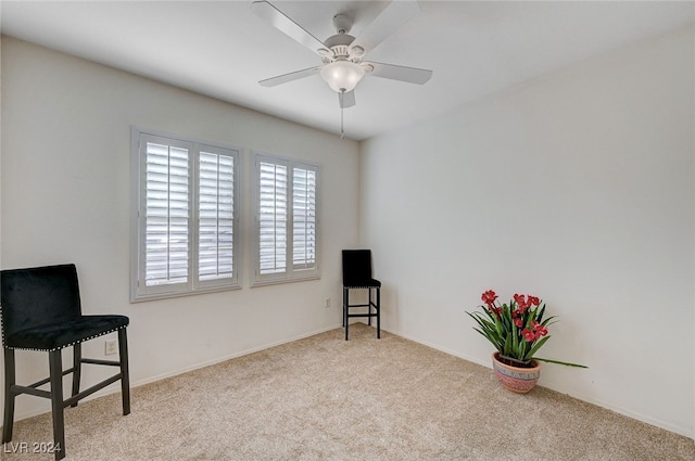 sitting room with ceiling fan and light colored carpet