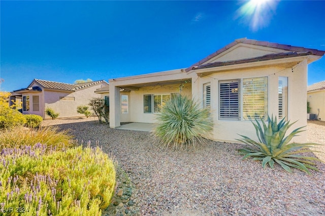 view of front of property with cooling unit and a patio area