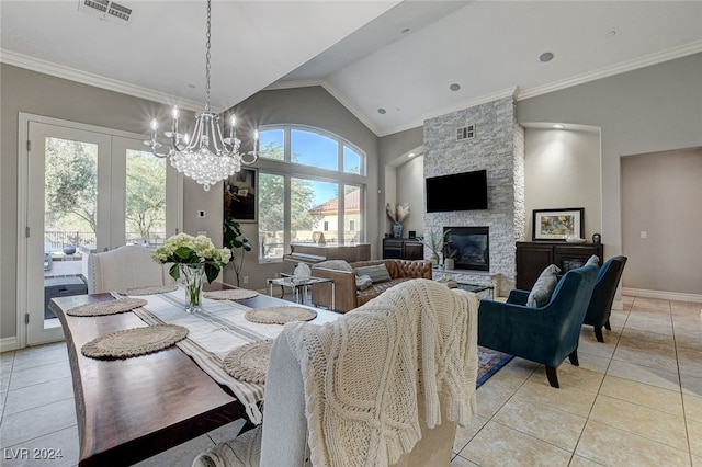 tiled dining room featuring a stone fireplace, high vaulted ceiling, crown molding, and a notable chandelier