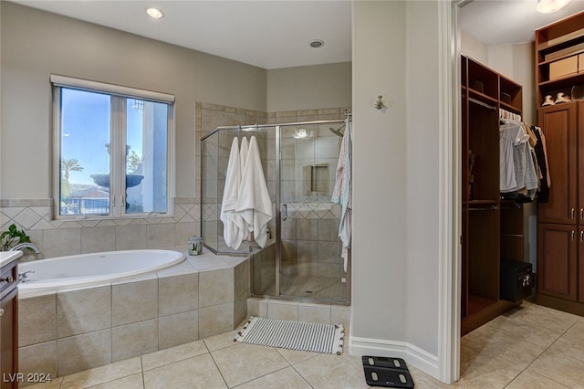 bathroom featuring vanity, plus walk in shower, and tile patterned flooring