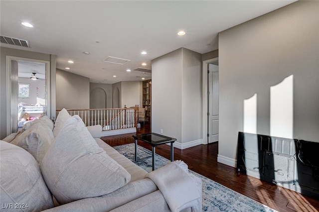 living room featuring dark wood-type flooring and ceiling fan