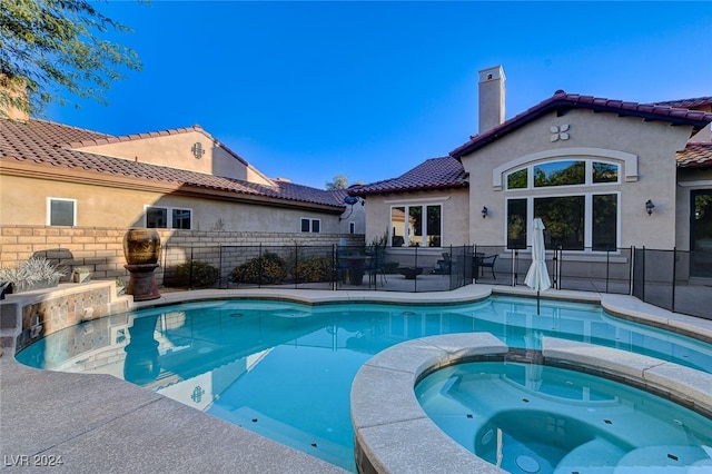 view of swimming pool with an in ground hot tub