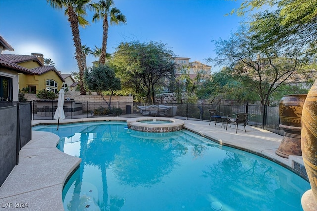 view of swimming pool featuring an in ground hot tub and a patio area