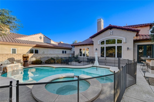 view of pool with an in ground hot tub and a patio area