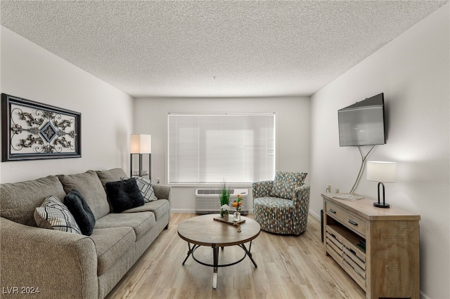 living room with a textured ceiling and light wood-type flooring