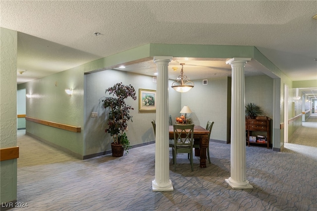 carpeted dining area with a textured ceiling and decorative columns