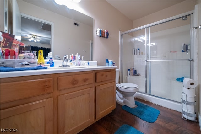 bathroom featuring toilet, a shower with door, vanity, wood-type flooring, and ceiling fan