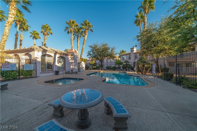 view of pool with a hot tub and a patio