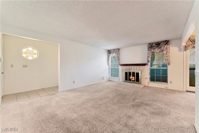 unfurnished living room with a textured ceiling, light colored carpet, and a fireplace