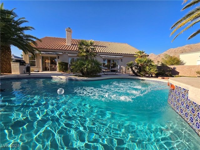 view of swimming pool featuring a mountain view and a patio